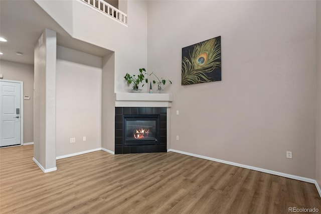 12919 W Burgundy Dr, Littleton, CO 80127 - unfurnished living room featuring wood finished floors, a tile fireplace, and recessed lighting