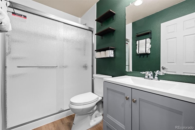 12919 W Burgundy Dr, Littleton, CO 80127 - bathroom with wood finished floors, a shower stall, a textured wall, and vanity