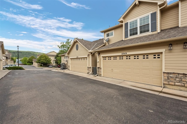 12919 W Burgundy Dr, Littleton, CO 80127 - view of front facade featuring stone siding and driveway