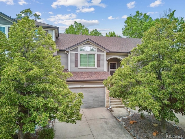 1441 S Ulster St, Denver, CO 80231 - view of front of house featuring a shingled roof, a garage, concrete driveway, and brick siding
