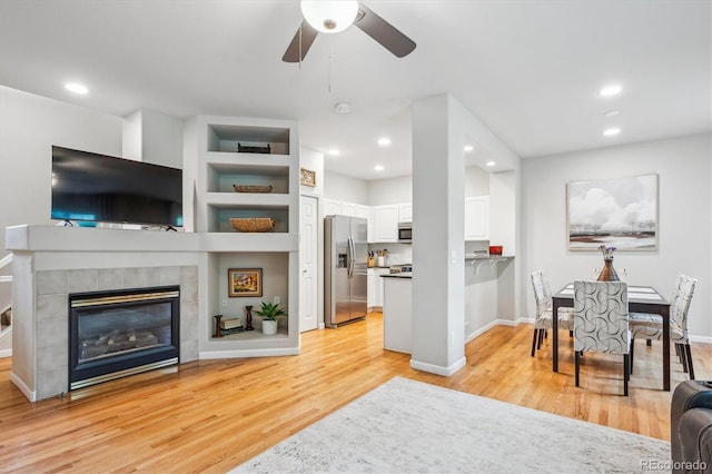 1441 S Ulster St, Denver, CO 80231 - living room with light wood-style flooring, ceiling fan, a tile fireplace, baseboards, and recessed lighting
