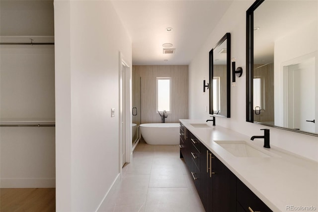 bathroom with tile patterned flooring, a tub, and vanity