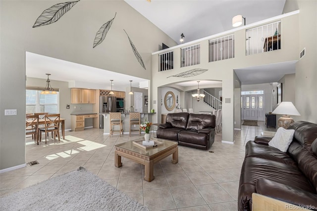 tiled living room with a chandelier and high vaulted ceiling