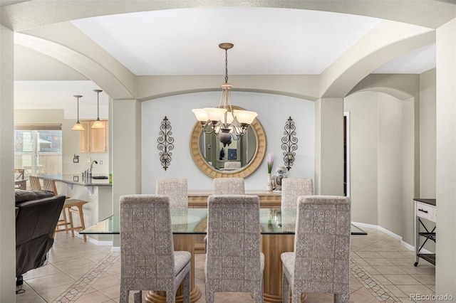 dining space with light tile patterned floors, sink, and a chandelier