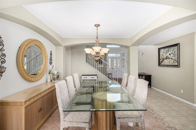 dining area featuring light tile patterned floors and an inviting chandelier