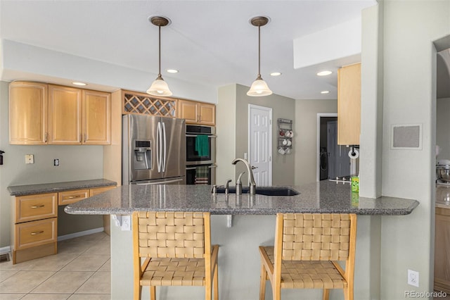 kitchen with sink, a kitchen bar, kitchen peninsula, and stainless steel appliances