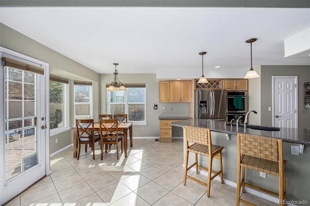 kitchen with sink, light tile patterned floors, stainless steel appliances, and hanging light fixtures