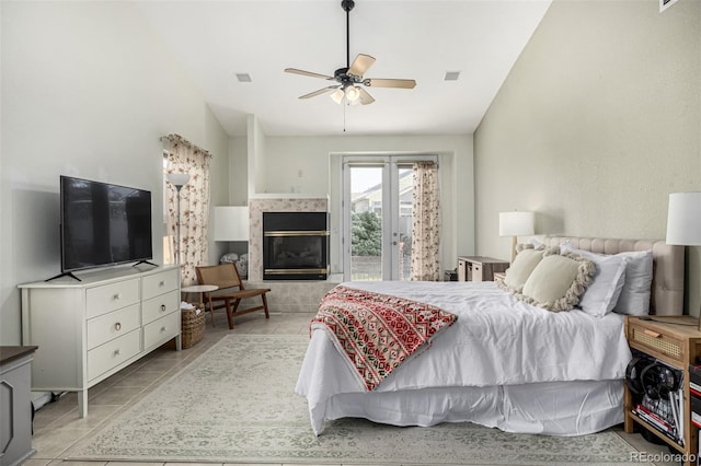 tiled bedroom featuring a fireplace, access to exterior, vaulted ceiling, and ceiling fan