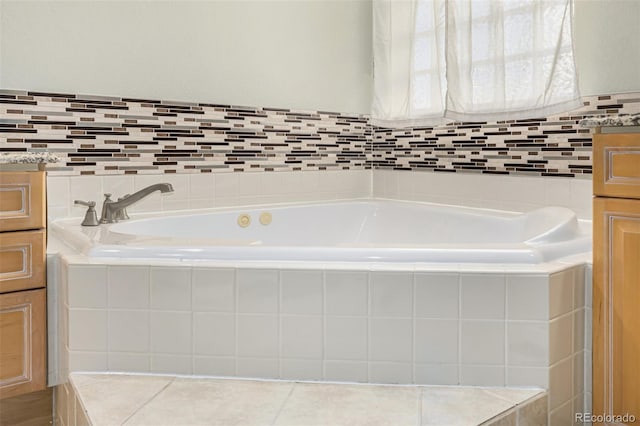 bathroom with vanity and tiled tub