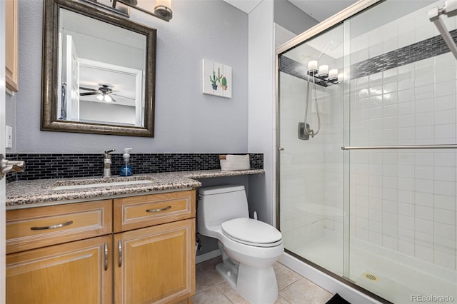 bathroom with decorative backsplash, tile patterned floors, vanity, toilet, and a shower with shower door