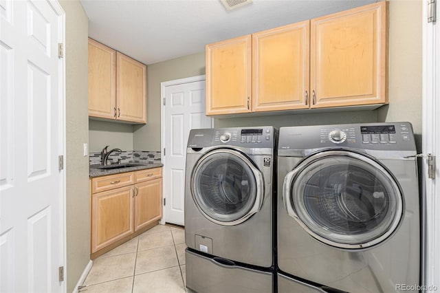 laundry area with washer and dryer, cabinets, light tile patterned floors, and sink