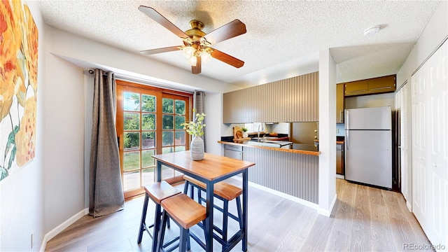 6836 W 79th Dr, Arvada, CO 80003 - dining area with light wood-style flooring, a ceiling fan, and a textured ceiling