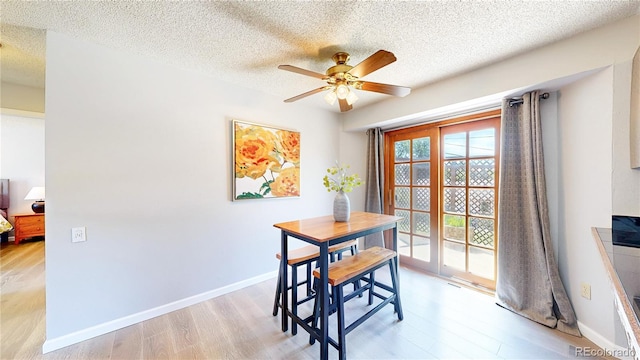 6836 W 79th Dr, Arvada, CO 80003 - dining space with light wood-style flooring, ceiling fan, and a textured ceiling