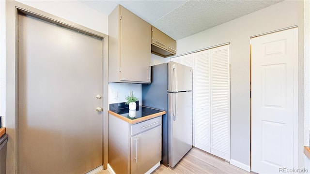 6836 W 79th Dr, Arvada, CO 80003 - kitchen with freestanding refrigerator, light wood-style flooring, and a textured ceiling