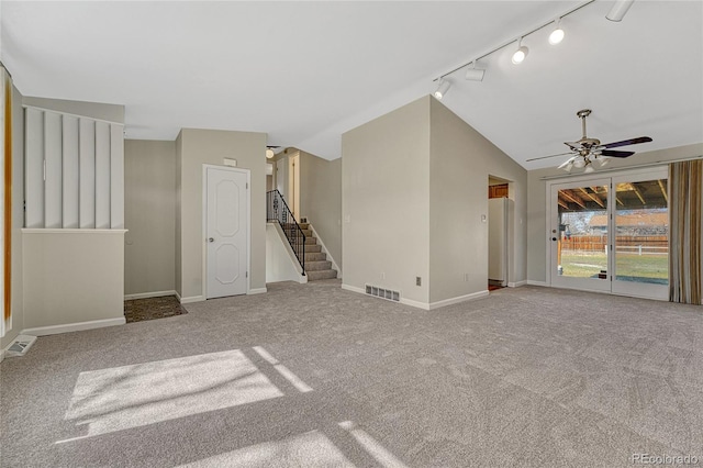 unfurnished living room featuring visible vents, ceiling fan, baseboards, stairs, and lofted ceiling