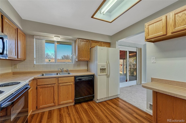 kitchen with tasteful backsplash, dishwasher, light countertops, white fridge with ice dispenser, and a sink