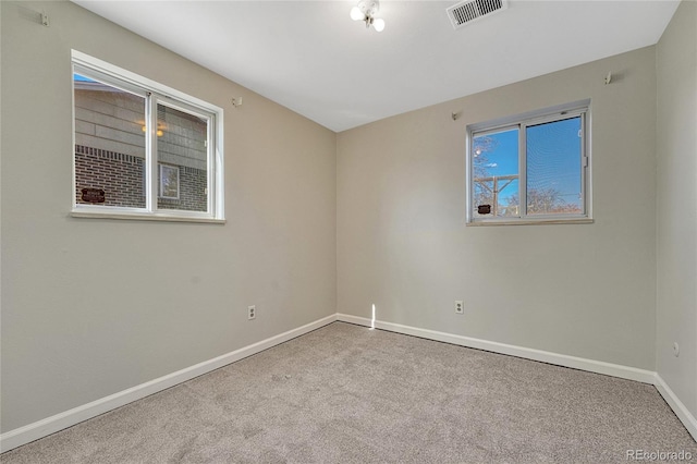 carpeted empty room with visible vents and baseboards