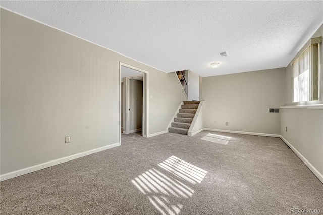 carpeted empty room with visible vents, stairs, and baseboards