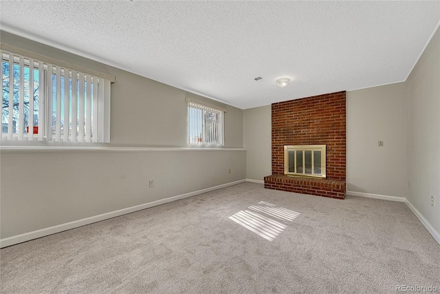 unfurnished living room featuring visible vents, a textured ceiling, carpet floors, a fireplace, and baseboards