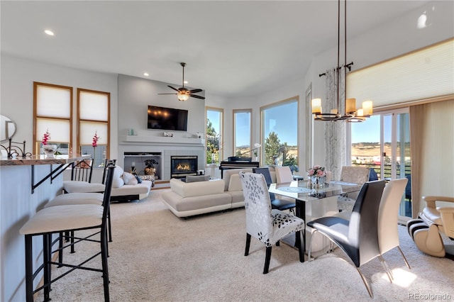 carpeted dining space with ceiling fan with notable chandelier