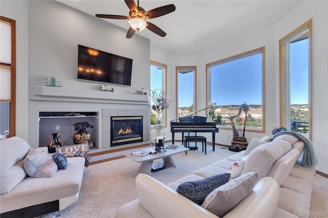 living room with ceiling fan, a tile fireplace, and carpet