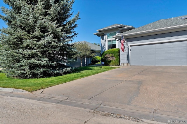 view of front of property featuring a garage and a front lawn