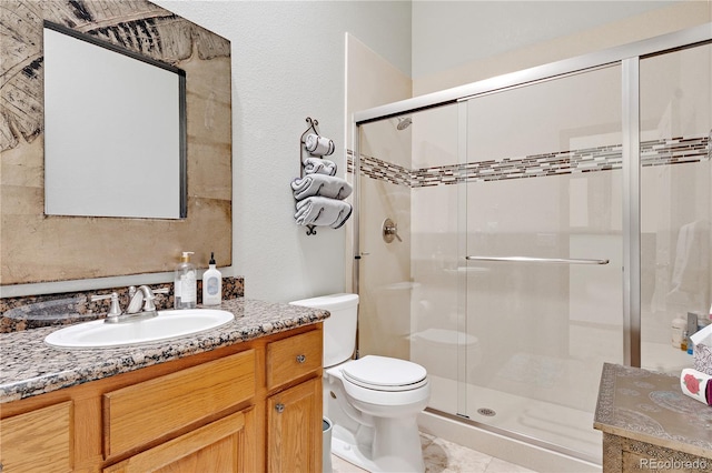 bathroom with vanity, toilet, and a shower with shower door