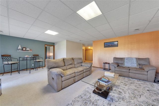 living room with a paneled ceiling and carpet