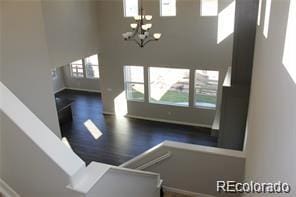 15305 W 93rd Ave, Arvada, CO 80007 - unfurnished living room featuring healthy amount of natural light, a chandelier, and wood finished floors