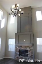 15305 W 93rd Ave, Arvada, CO 80007 - unfurnished living room with a chandelier and baseboards