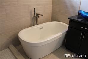 15305 W 93rd Ave, Arvada, CO 80007 - full bathroom with a freestanding tub, tile walls, and vanity