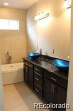 15305 W 93rd Ave, Arvada, CO 80007 - bathroom featuring a bath and double vanity