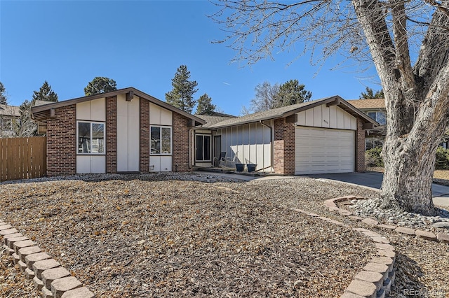 view of front facade with board and batten siding, brick siding, fence, and an attached garage