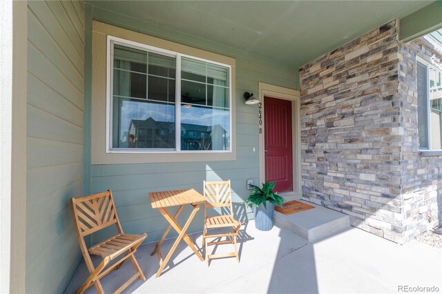 2640 Brookstone Dr Unit B, Milliken, CO 80543 - doorway to property with stone siding and covered porch
