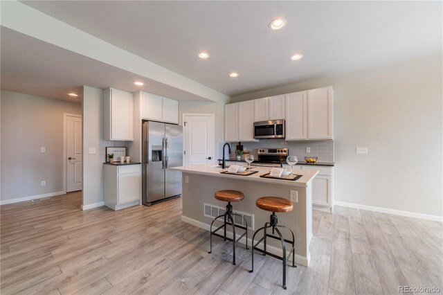2640 Brookstone Dr Unit B, Milliken, CO 80543 - kitchen featuring stainless steel appliances, light wood-style floors, backsplash, a breakfast bar, and recessed lighting