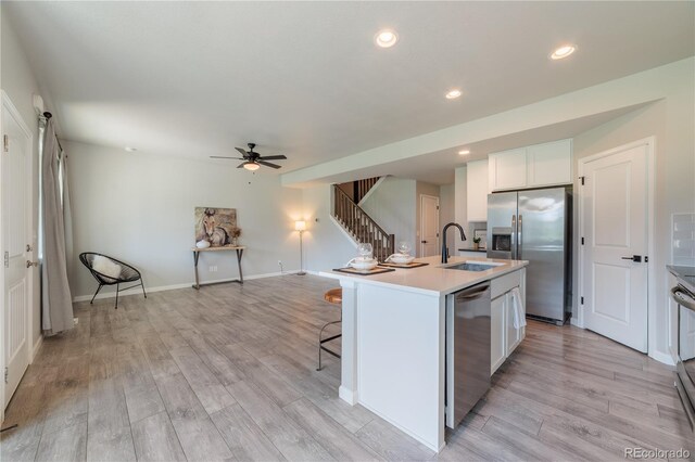 2640 Brookstone Dr Unit B, Milliken, CO 80543 - kitchen with appliances with stainless steel finishes, ceiling fan, light wood-style flooring, light countertops, and a breakfast bar