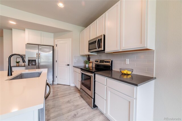 2640 Brookstone Dr Unit B, Milliken, CO 80543 - kitchen featuring appliances with stainless steel finishes, backsplash, white cabinetry, and recessed lighting