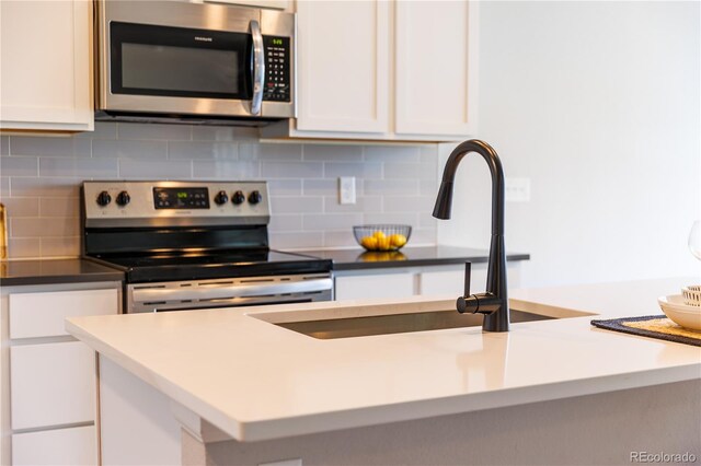 2640 Brookstone Dr Unit B, Milliken, CO 80543 - kitchen featuring appliances with stainless steel finishes, white cabinets, and backsplash