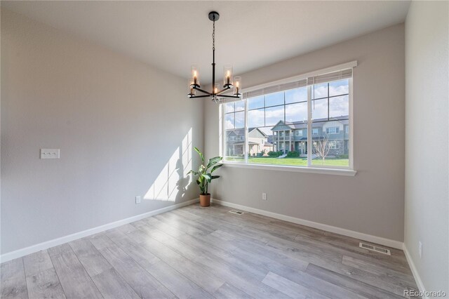 2640 Brookstone Dr Unit B, Milliken, CO 80543 - spare room with a chandelier and wood finished floors