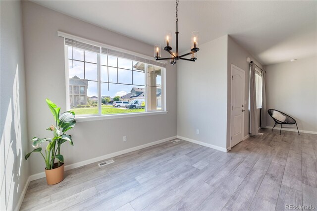 2640 Brookstone Dr Unit B, Milliken, CO 80543 - unfurnished dining area with a chandelier, wood finished floors, and a barn door