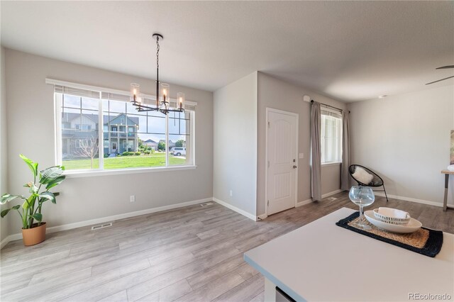 2640 Brookstone Dr Unit B, Milliken, CO 80543 - dining space featuring light wood-style flooring, plenty of natural light, and a chandelier