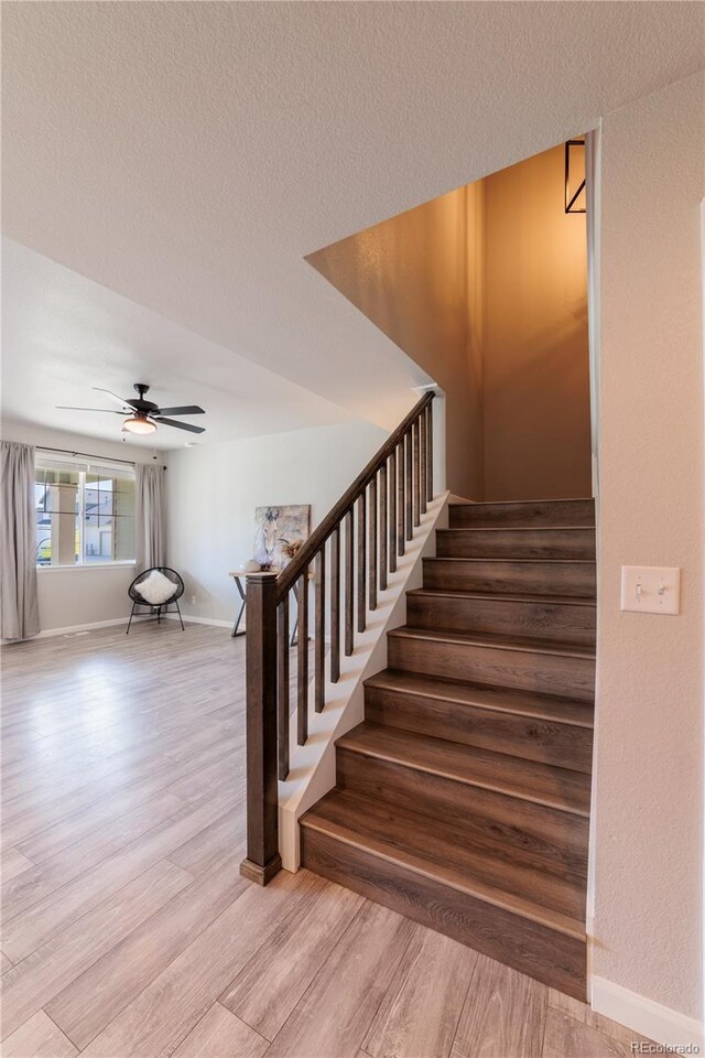 2640 Brookstone Dr Unit B, Milliken, CO 80543 - stairs featuring wood finished floors, ceiling fan, and a textured ceiling
