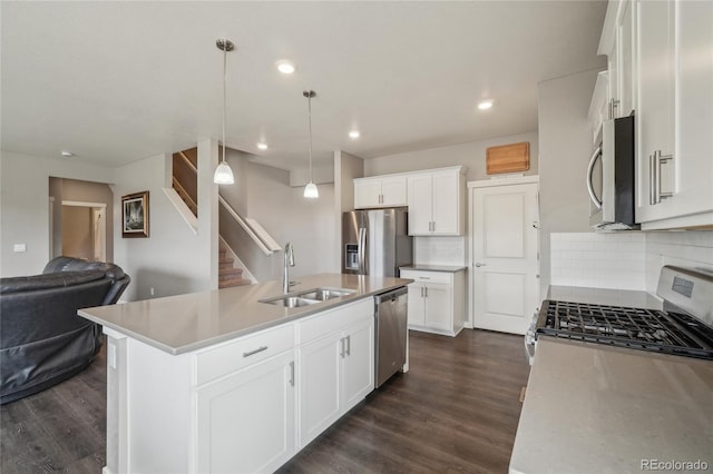 kitchen with dark wood-style floors, open floor plan, appliances with stainless steel finishes, and a sink