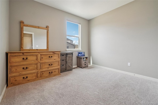 bedroom with light colored carpet and baseboards