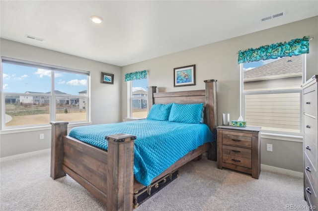 bedroom with baseboards, light carpet, and visible vents