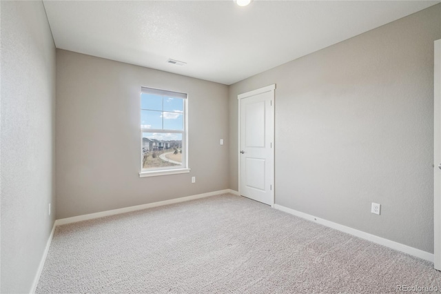 unfurnished room featuring light colored carpet, visible vents, and baseboards
