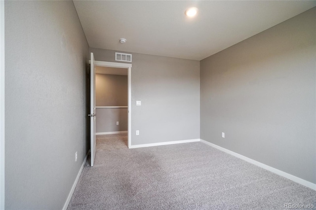 carpeted empty room with visible vents and baseboards