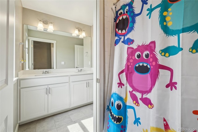 bathroom with a sink, double vanity, curtained shower, and tile patterned flooring