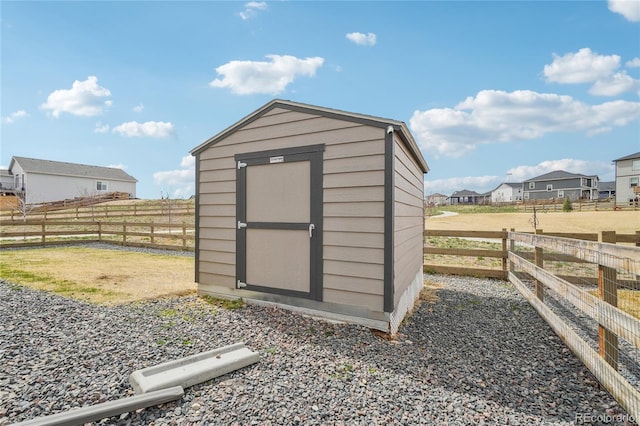 view of shed featuring fence and a residential view