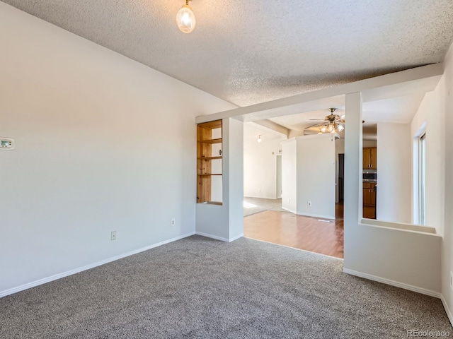 spare room featuring ceiling fan, carpet, and a textured ceiling